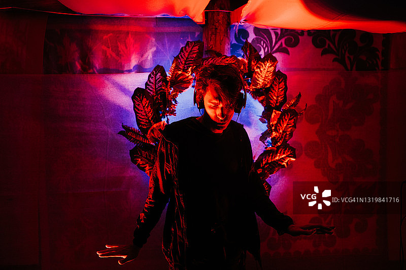 在聚会上戴着耳机的年轻英俊男子图片素材