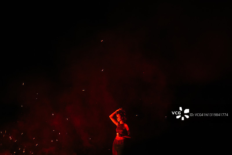 在明亮红光中的美丽年轻女子图片素材