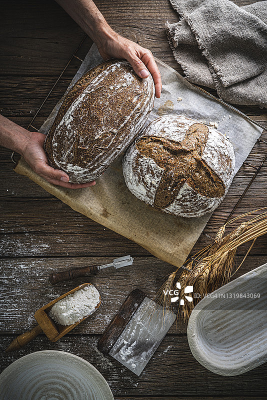 面包师手持面包、酸面包和发酵篮图片素材