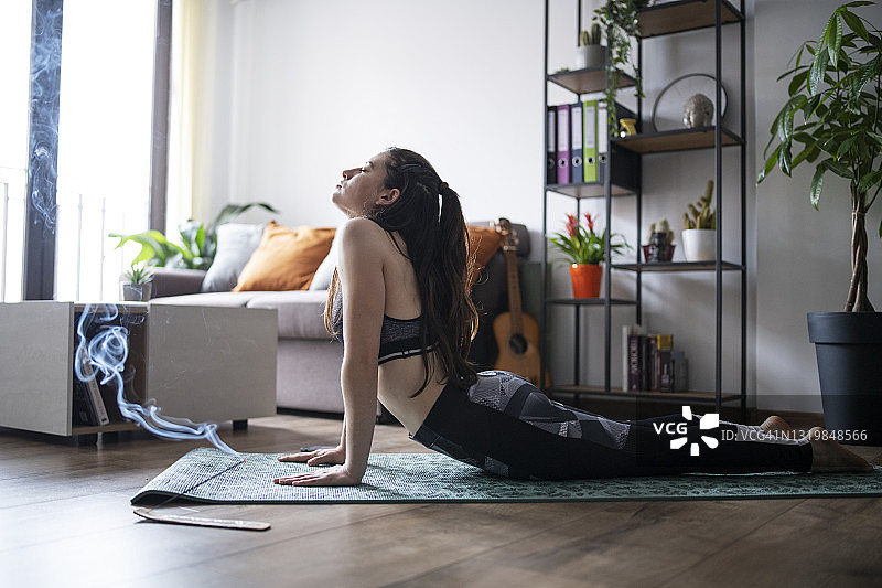 年轻女子在家练习瑜伽图片素材