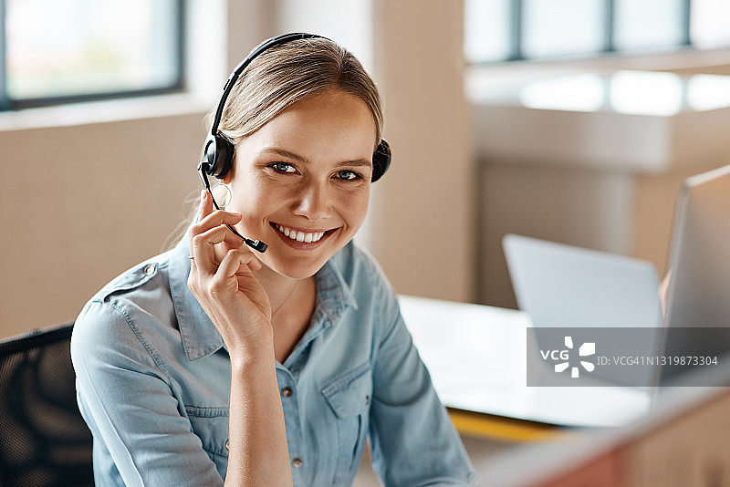 在办公室工作戴耳机的年轻女商人肖像图片素材