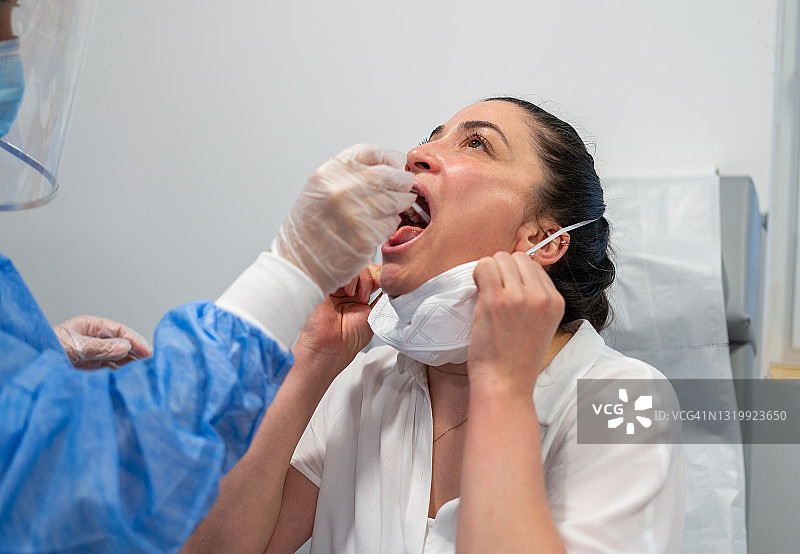 医护人员在医院为疑似感染新冠病毒的女性取样图片素材