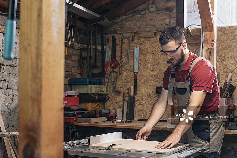 在车间制作家具的英俊木匠图片素材