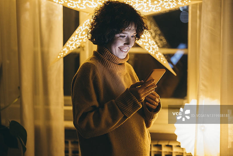 疫情期间的社交：一位快乐的年轻女性通过智能手机与朋友进行视频通话的肖像图片素材