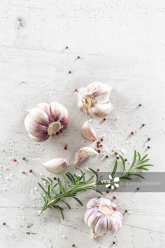 由蒜头、蒜瓣、迷迭香和各种辣椒组成的大蒜食品概念俯视图图片素材