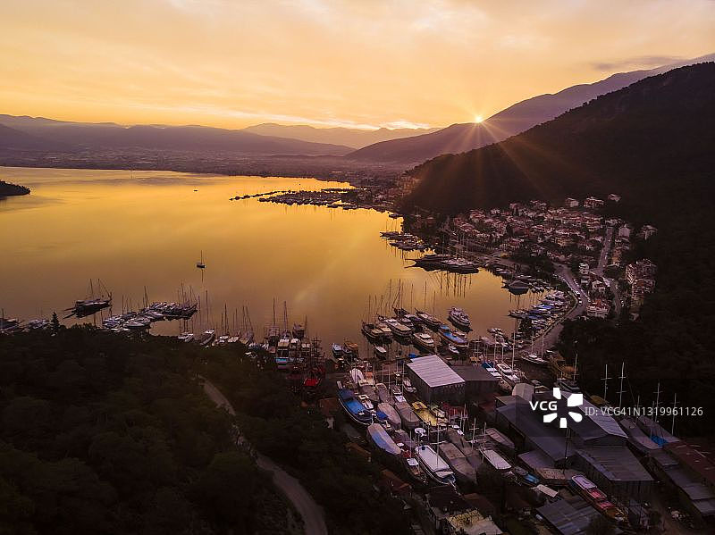 日出时分，群山环绕的宁静港口鸟瞰图片素材