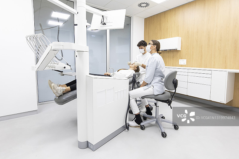牙科保健师和助理清洁病人牙齿图片素材