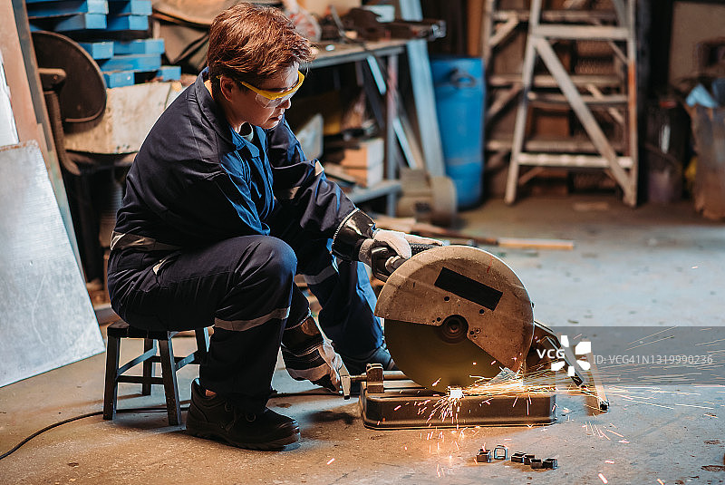 在车间切割金属的中国女焊工图片素材