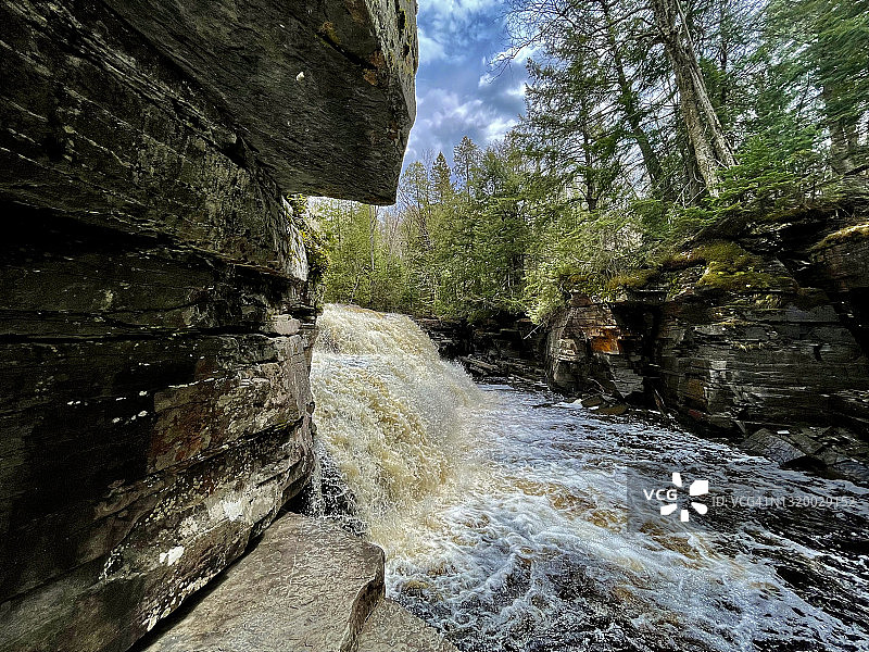 沿着崎岖小径徒步旅行，欣赏峡谷瀑布的岩层和美丽的河流景观图片素材