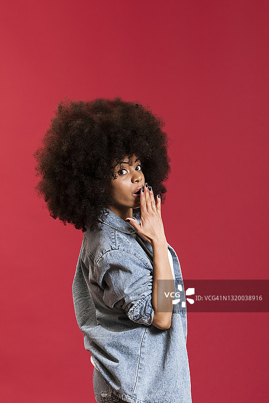 黑人女人在红色背景上捂住嘴巴图片素材