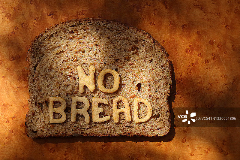 一片小麦面包，上面有用烘焙面团字母制成的“NO BREAD”字样 - 系列的一部分图片素材