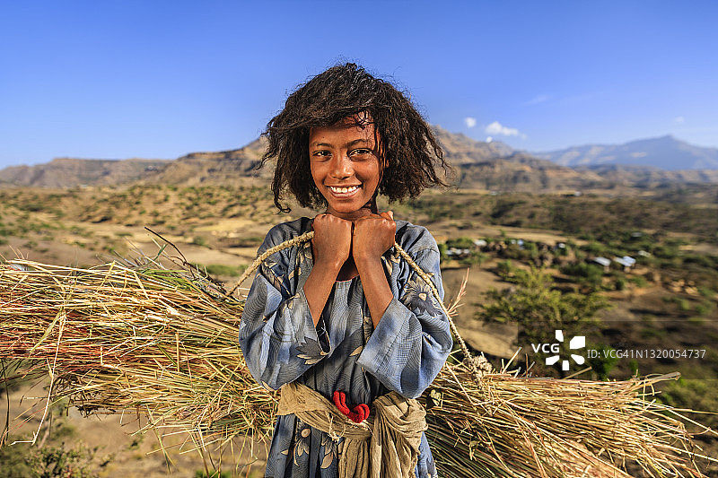 非洲东部地区携带稻草的年轻女孩肖像图片素材