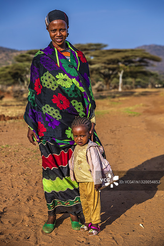 来自埃塞俄比亚博拉纳部落的抱着婴儿行走的女人图片素材