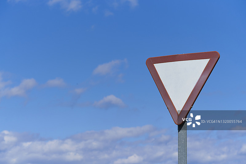 道路上让行标志的空白标志牌，天空和云彩背景图片素材