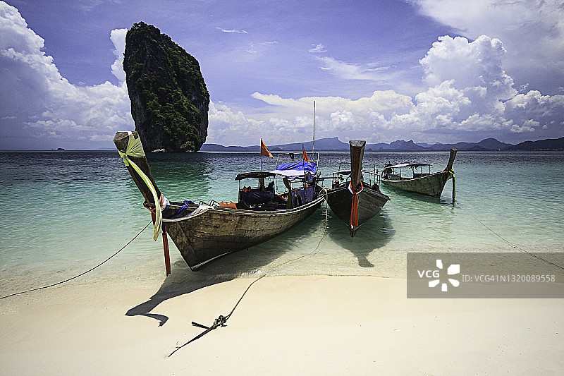 泰国甲米府波达岛清澈水域上的传统长尾船图片素材