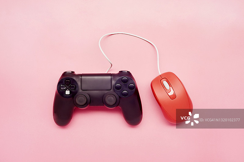 粉色背景上的游戏手柄和红色鼠标俯视图图片素材