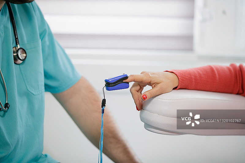 用血氧仪测量女性患者的血氧饱和度图片素材