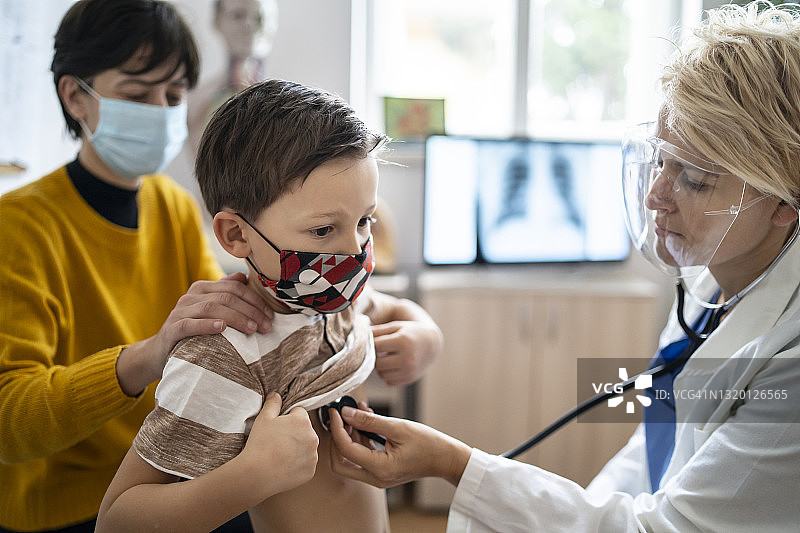 新冠疫情期间女医生检查小患者的呼吸图片素材