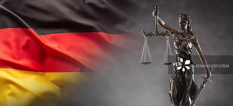 蒙眼的正义女神雕像，象征着法律，手持天平和剑，背景是德国国旗图片素材