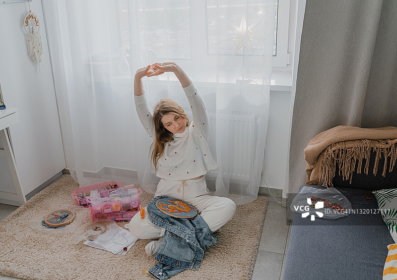 在家刺绣后伸展身体的女人图片素材