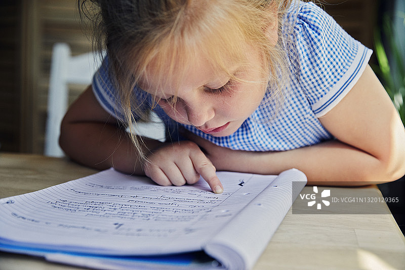 孩子在作业本上做笔记图片素材