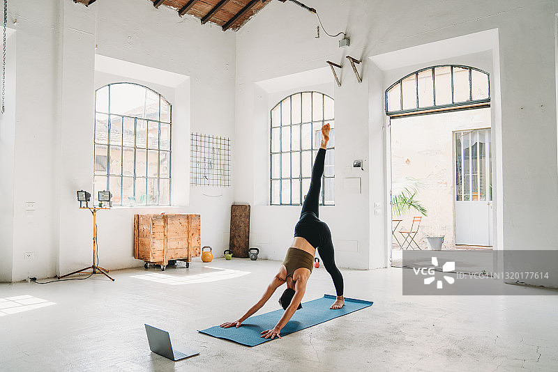 年轻瑜伽老师用笔记本电脑进行在线视频教学图片素材