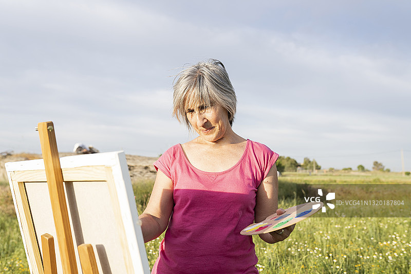 银发女人在户外绘画图片素材
