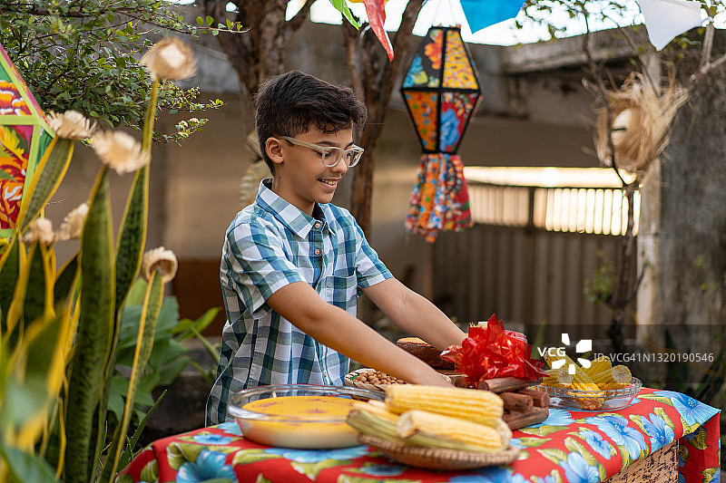 男孩在六月节摆放典型餐食图片素材