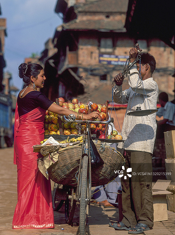尼泊尔妇女在街上购买水果图片素材