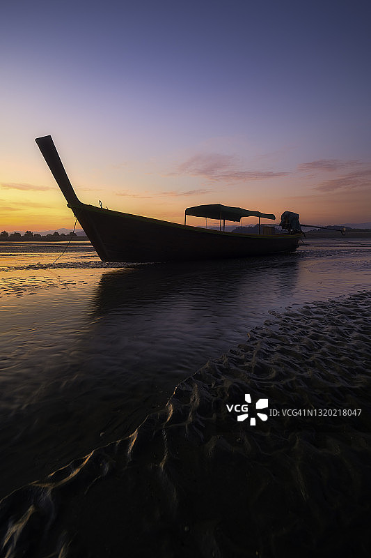 泰国南部沙滩上美丽的日出天空与长尾船图片素材