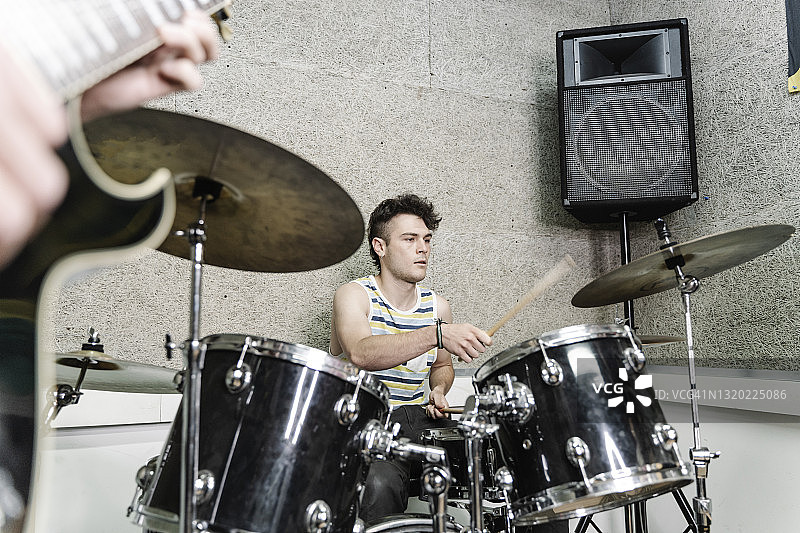 穿背心的青年鼓手与乐队一起演奏图片素材
