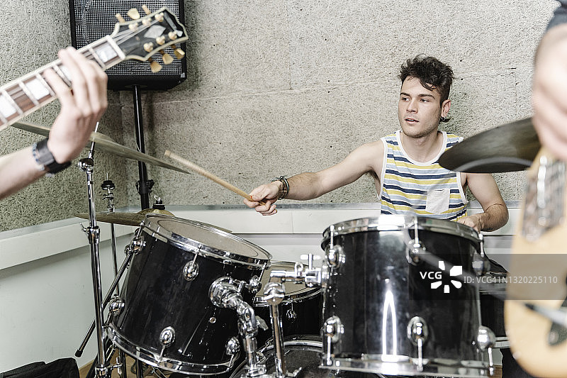 穿背心的青年鼓手与乐队一起演奏图片素材