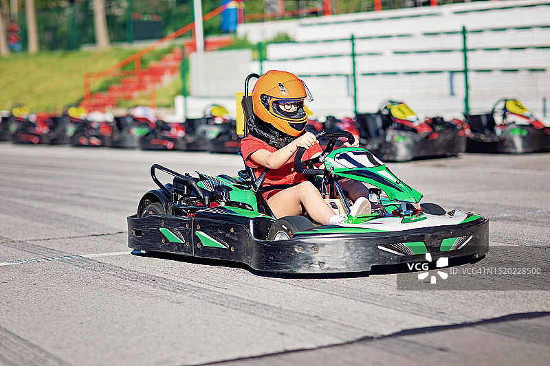 女孩在赛道上驾驶卡丁车图片素材
