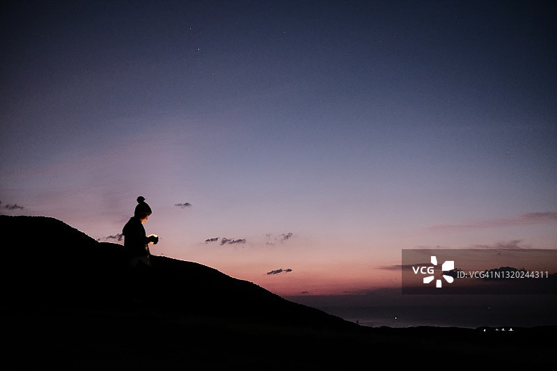 男孩站在晨曦中拿着灯图片素材