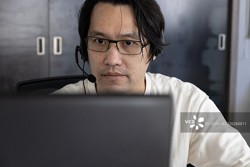 佩戴呼叫中心耳机的亚洲客服人员图片素材