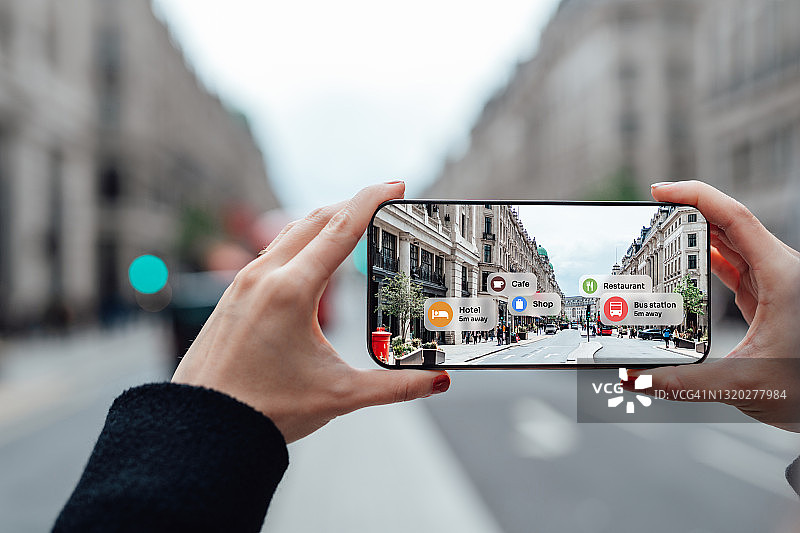 在街上使用增强现实技术在智能手机上寻找方向图片素材