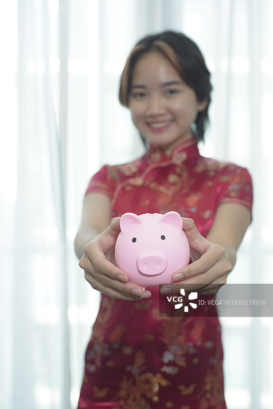 中国或马来西亚混血美女手 holding 储蓄罐图片素材
