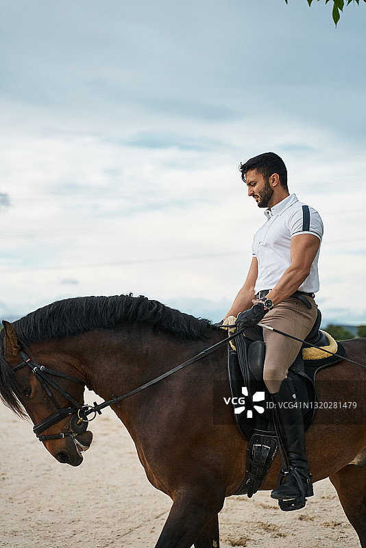 年轻男子在享受大自然中的骑马乐趣图片素材