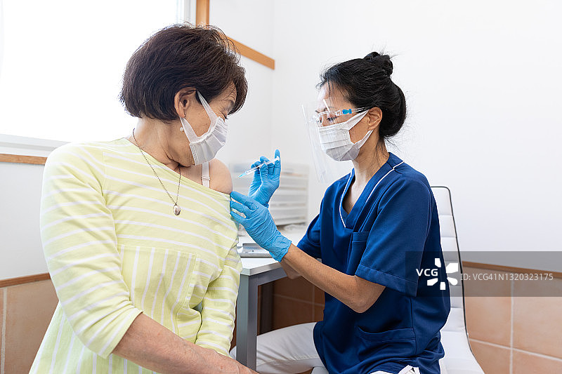 女医生为老年妇女接种疫苗图片素材