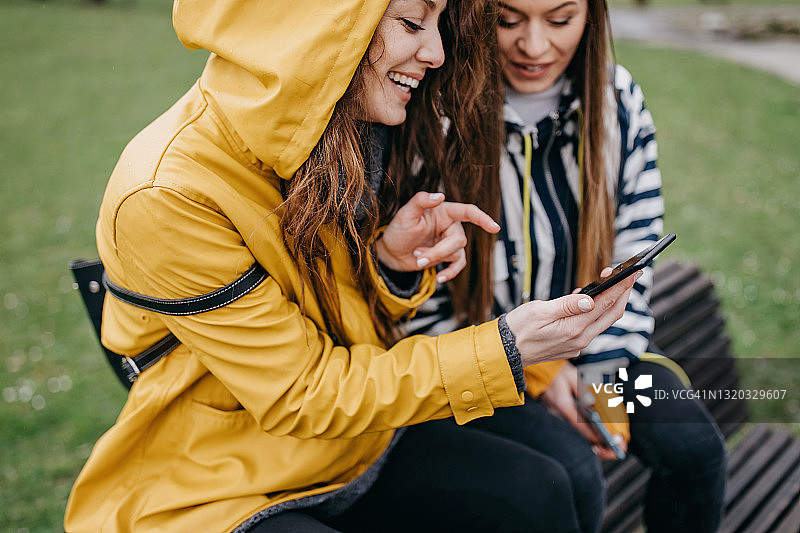 朋友们在公园里使用手机图片素材