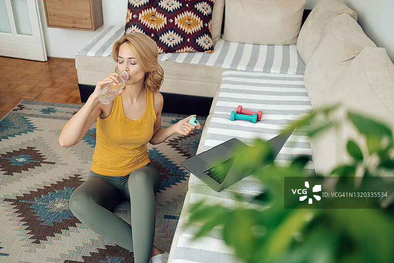 在家锻炼后喝水补充水分的女人图片素材