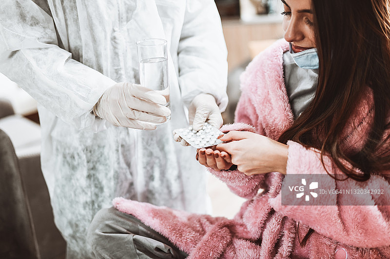 女人接受穿着防护服的医生抗新冠治疗图片素材