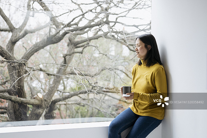 在家喝茶放松的中国中年妇女图片素材