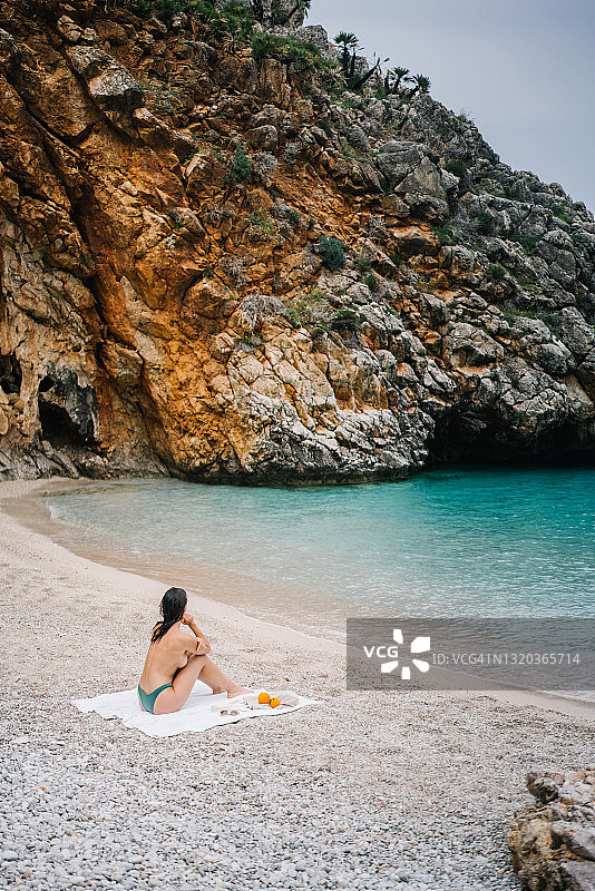 年轻女子在地中海海滩上沐浴阳光图片素材