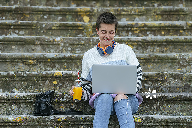 在街上使用笔记本电脑的女人图片素材