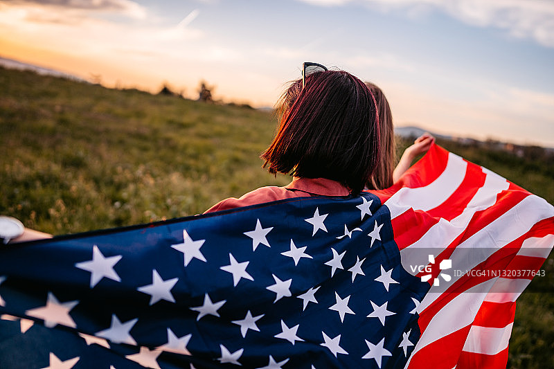 两名女人在草地上用美国国旗遮盖身体图片素材
