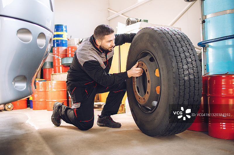 技工在修理厂更换公共汽车车轮图片素材