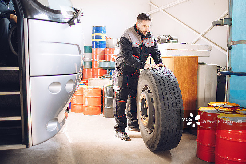 技工在修理厂更换公共汽车车轮图片素材