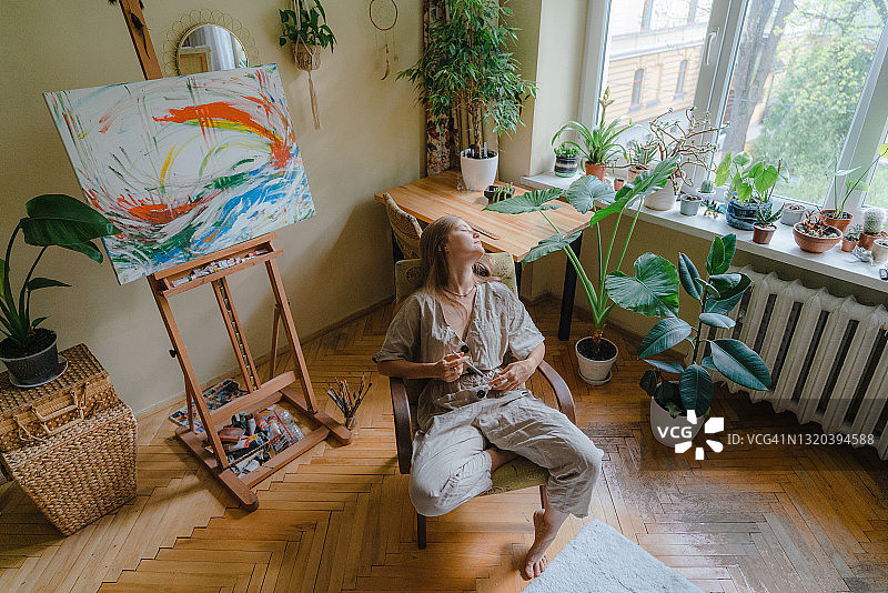 坐在家中扶手椅上的女画家图片素材