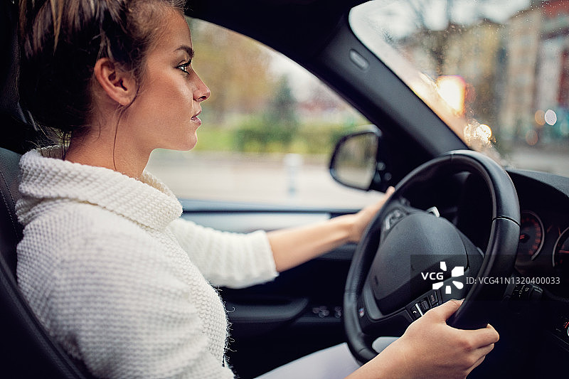 年轻女人在城市中开车图片素材